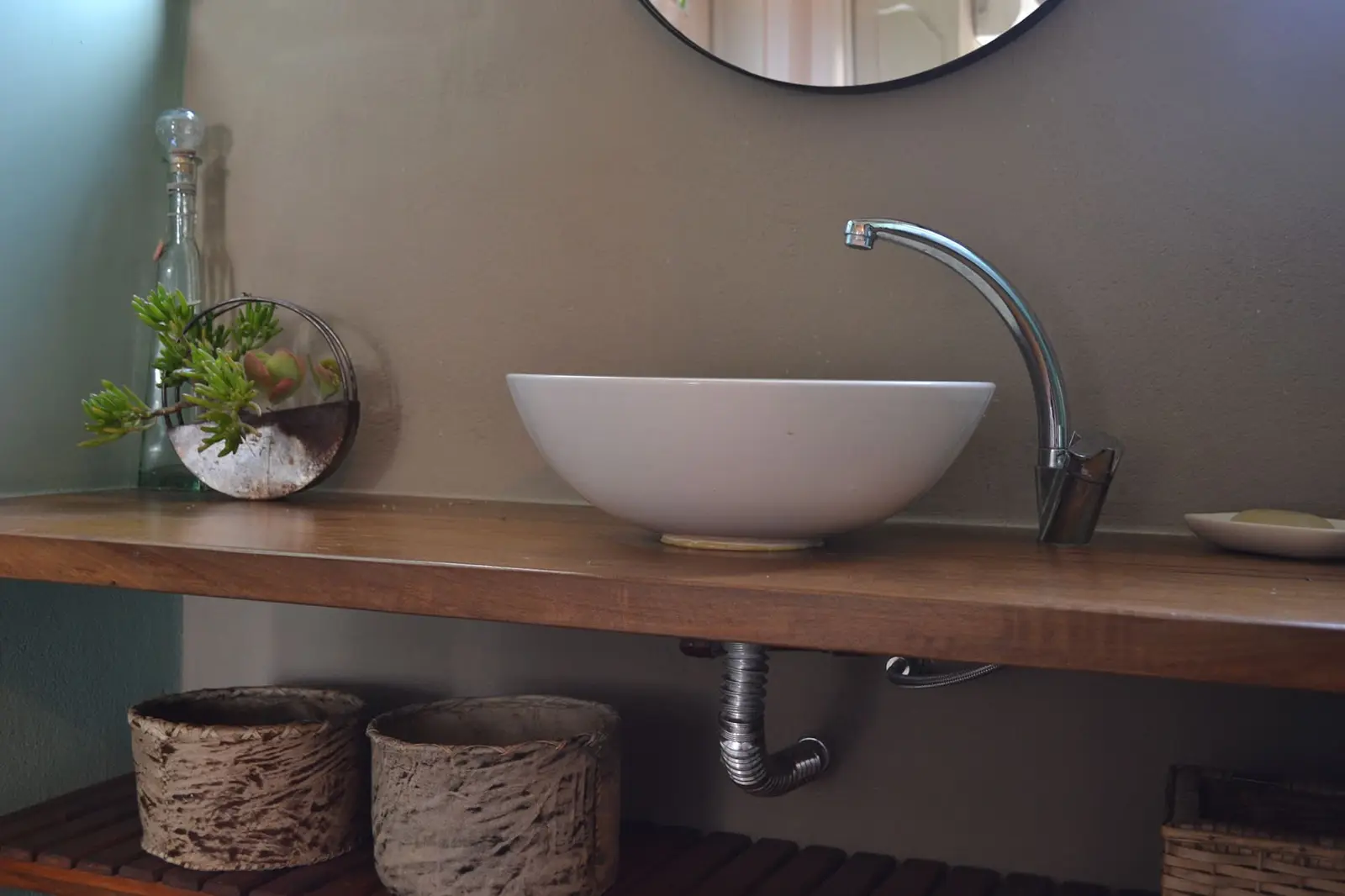 Baño con bacha de apoyo y mesada de madera