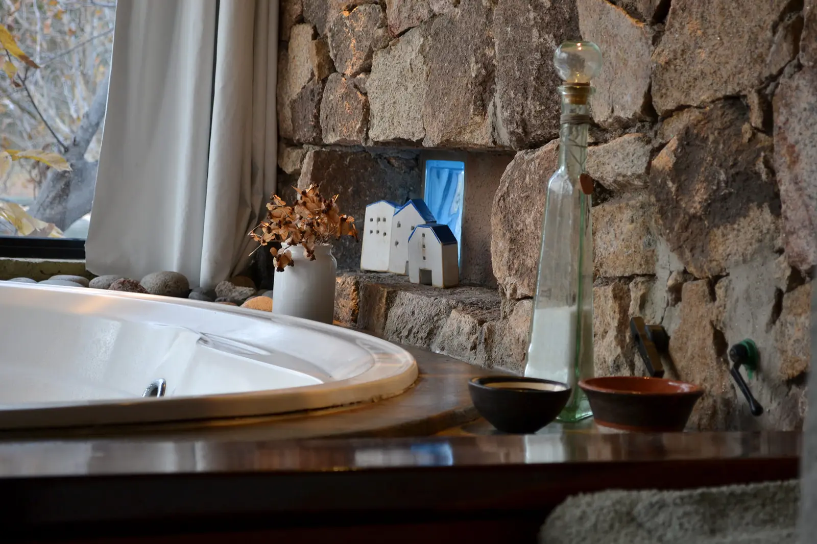 Jacuzzi doble junto a la pared de piedra